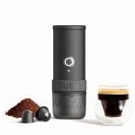 OutIn Mino Space Grey mobile Espressomaschine mit Kaffeepulver, Kapsel und frisch zubereitetem Espresso
